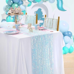 Detail of light blue sequin table runner and chair sashes in a mermaid party setting