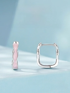 Macro view of square S925 sterling silver hoop earrings with pink enamel wave texture