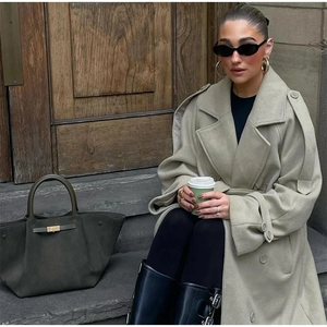 Women's oversized beige wool coat with scarf design and dark olive leather tote bag