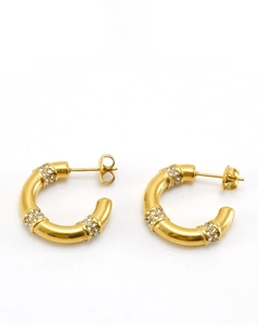 Detailed view of 18K gold plated C-shaped geometric earrings with sparkling zircon inlay