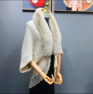 Elegant ivory knit poncho with plush faux fur collar and fringe tassels for autumn