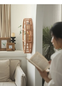 Detail of a three-tier oval bamboo wall shelf with natural textures on a white wall