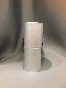 Close-up of silver PU leather cylindrical makeup brush storage case with snap button