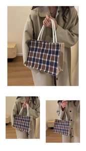 Close-up of brown and blue plaid canvas tote bag with white rope handles and structured design