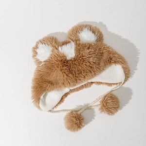 Detailed view of the soft plush earflap hat featuring cute bear ears and braided pompom ties