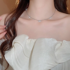 Macro shot of silver stainless steel necklace with a clear zircon pendant on model neck