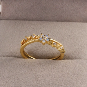 Détail macro d'une bague fleur dorée avec cristaux étincelants dans son écrin en velours