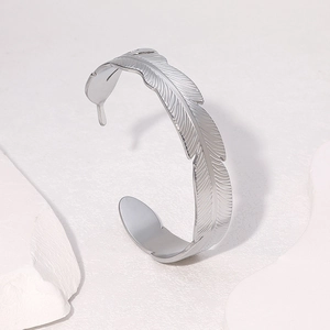 Minimalist silver feather cuff bracelet in stainless steel with detailed leaf texture