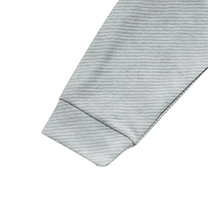 Close-up detail of grey twill fabric texture and stitching on the jacket sleeve cuff