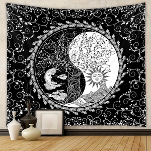 Detail of bohemian tapestry featuring tree of life sun and moon patterns in black and white