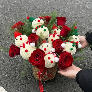Christmas flower basket with red roses and snowman pom-poms in a woven grass basket