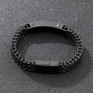 Macro detail of black stainless steel Cuban chain bracelet with magnetic clasp on dark glitter