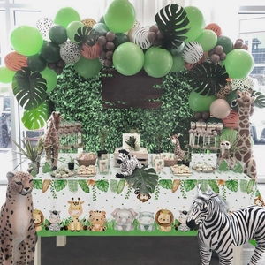 Jungle safari party setup with animal balloons, cartoon tablecloth and plush forest toys