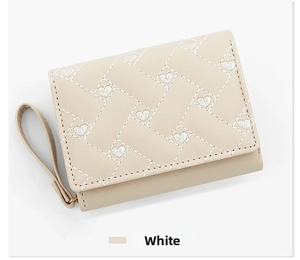 Detail of cream white faux leather trifold wallet featuring embroidered heart stitching