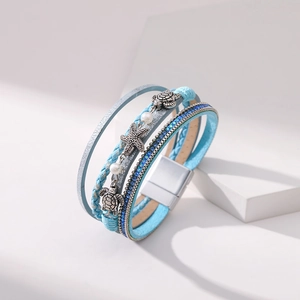Detail of light blue layered leather bracelet with silver sea turtle and starfish charms