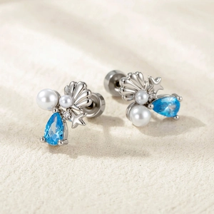 Ocean series starfish and shell earrings with blue zircon and pearls on beige fabric