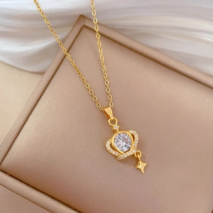 Macro shot of gold crown and star pendant with sparkling crystals on jewelry box