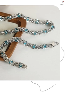 Detailed close-up of a silver Byzantine chain with blue beads and a sturdy lobster clasp