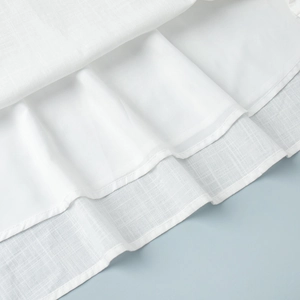 Close-up of white cotton skirt hem with textured outer fabric and smooth inner lining
