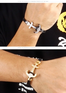 Détail de bracelets ancre avec cristaux pavés et sangles en cuir tressé noir