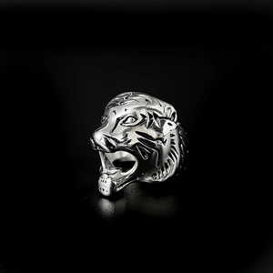 Dettaglio macro di un anello a testa di tigre in argento con texture metalliche