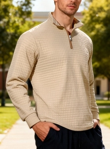 Detailed view of beige waffle knit texture and quarter-zip collar on men's pullover