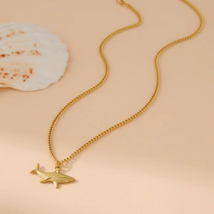 Minimalist 18k gold plated stainless steel shark pendant necklace on beige background