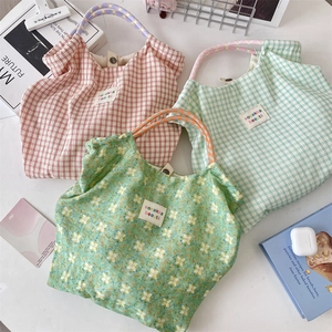 Vista dettagliata di tre borse shopper a scacchi in rosso, verde e motivi floreali