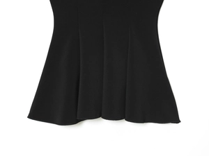 Detail of black elastic top showing ruffled hemline and high-quality knit fabric texture
