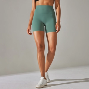 Detail of high-waist yoga shorts in sage green fabric with slimming compression fit