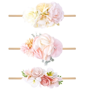Detailed close-up of three floral baby headbands with soft fabric petals and nylon bands