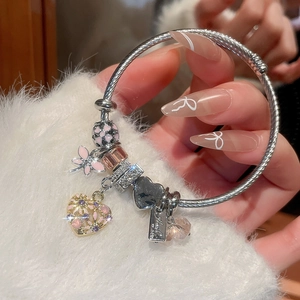 Close-up of beaded heart charm bracelet with pink enamel flowers and sparkling crystals