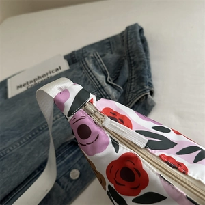 Large floral print crossbody bag with colorful patterns and adjustable webbing strap