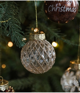 Champagne and brown glitter Christmas balls hanging on green pine tree branches
