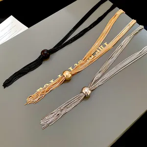 Dettaglio di collane con nappe multistrato in nero, oro e argento con sfere di metallo