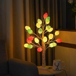 Close-up of Easter birch tree lights with cracked colorful LED eggs on a marble table