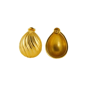 Detail of gold teardrop earrings showing spiral texture and hollow back design