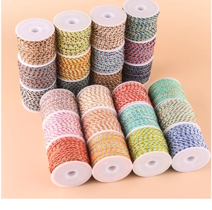 Detail of colorful braided cotton threads with gold accents on white spools for DIY jewelry