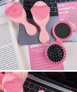 Pink heart plush pocket hairbrush and folding mirror comb set on desktop