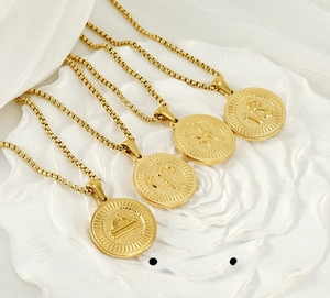 Vue macro de colliers zodiacaux en acier doré avec pendentifs pièces sur support floral