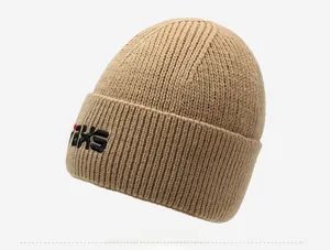 Detailed close-up of light camel knit beanie showing rib texture and side logo embroidery