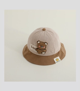 Detail of baby corduroy sun hat with patchwork design and 3D bear decoration