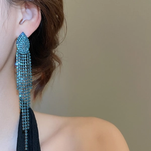 Close-up of vibrant blue rhinestone jellyfish tassel earrings on a model profile