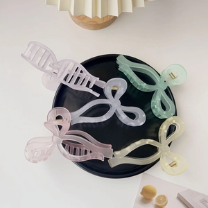 Five matte acrylic hair claws in pastel colors displayed on a black circular plate