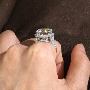 Detailed side view of halo engagement ring with pavé diamonds and intricate openwork setting