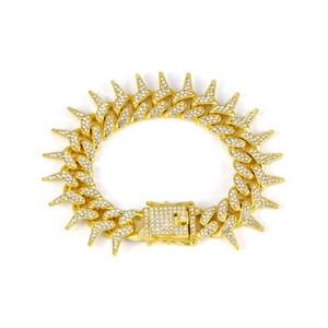 Close-up of gold iced-out 20mm spike Cuban chain bracelet with paved faux diamonds