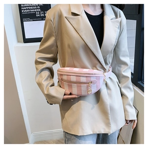 Detail of pink and white striped chest bag with gold pendant shown on model