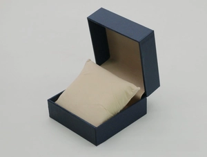 Detail view of navy blue faux leather watch box with a soft beige interior cushion