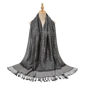 Dark grey paisley pattern scarf with long black tassels on a professional mannequin