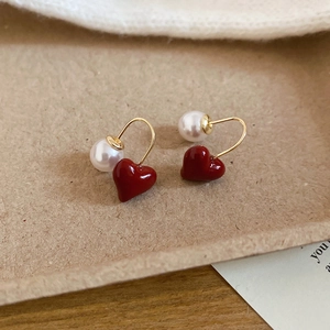 Dettaglio degli orecchini a cuore fragola e perla con ganci dorati in confezione regalo